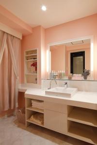 a bathroom with a sink and a mirror at HOTEL Birthday 楠店 in Toyoyama