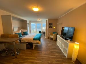 a bedroom with a bed and a tv and a couch at FeWo Gretchen in Berchtesgaden