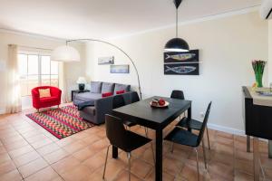 ein Wohnzimmer mit einem Tisch und einem Sofa in der Unterkunft Casa Pedrinho (Terraços de Benagil 41) in Benagil