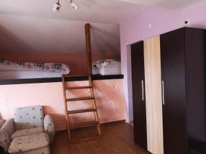 a room with a ladder and a chair and bunk beds at Къща Зорница in Brestovitsa