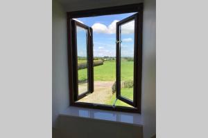 a window in a room with a view of a field at Meadow View @ Glebe Barn in Pershore