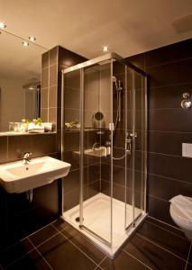 y baño con ducha y lavamanos. en Hotel Jakob Regensburg, en Regensburg