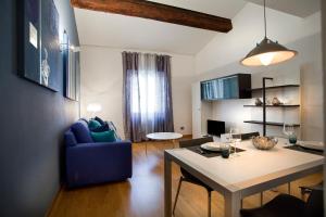 un soggiorno con tavolo e sedia blu di FILARMONICO SUITES a Verona
