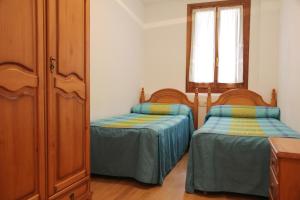 1 dormitorio con 2 camas individuales y ventana en La Coma De Alba, en Benasque