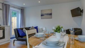 uma sala de jantar com uma mesa de madeira com cadeiras e uma sala de jantar em Didcot- Private Flat with Garden & Parking 04 em Didcot