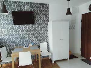 ein Esszimmer mit einem Tisch und einem TV an der Wand in der Unterkunft Apartament Kasprowy Jaszczurówka in Zakopane