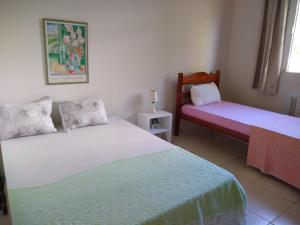 a bedroom with two beds and a lamp on a table at Dr Chico Beach House Peroba in Maragogi