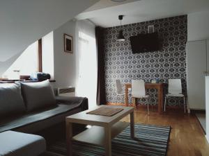 ein Wohnzimmer mit einem Sofa und einem Tisch in der Unterkunft Apartament Kasprowy Jaszczurówka in Zakopane