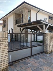 a metal fence with a wooden deck on a house at Apartment ANNO in Dunajská Streda