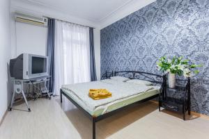 ein kleines Schlafzimmer mit einem Bett und einem TV in der Unterkunft Tarasa Shevchenko Boulevard 10 in Kiew