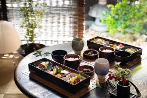 a table with three trays of food on it at THE JUNEI HOTEL Kyoto Imperial Palace West in Kyoto