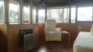 Zimmer mit einem Bett, einem Stuhl und Fenstern in der Unterkunft Pazo da Merced in Neda