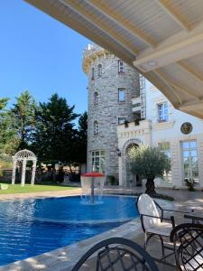 a swimming pool with a fountain in front of a building at Castle Konti in Tirana