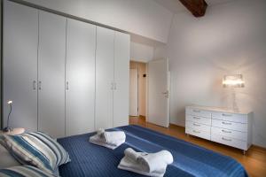 um quarto com uma cama azul com toalhas em FILARMONICO SUITES em Verona