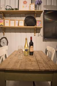 Koselig Hytte i Hemsedal في هيمسيدال: طاولة مع زجاجتين من النبيذ وكوب