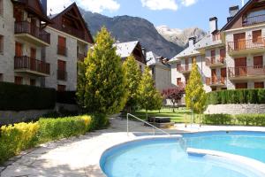 uma piscina no meio de um pátio com edifícios em La Coma De Alba em Benasque