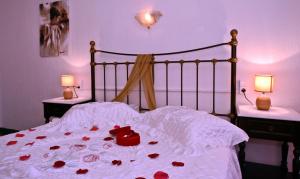 a bed with red roses on it with two lamps at Maria Studios in Neo Klima