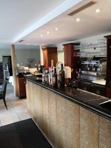 a large kitchen with a bar in a restaurant at Hotel & Ristorante Il Duomo in Olpe