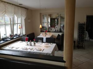 a dining room with a table with a white table cloth at Hotel & Ristorante Il Duomo in Olpe