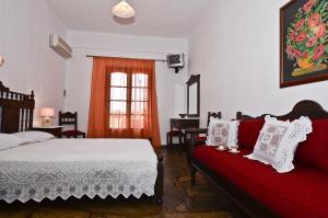 a bedroom with a bed and a red couch at Maria Studios in Neo Klima