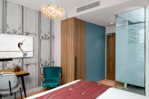 um quarto com uma cama, uma secretária e uma cadeira em Lyric Hotel Paris Opera em Paris