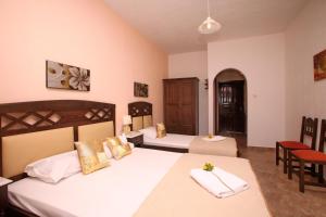 a bedroom with two beds and a table and chairs at Maria Studios in Neo Klima