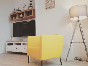 グロヴェにあるFerienwohnung Bella Elisaのリビングルーム(黄色い椅子、テレビ付)