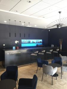 a bar in a restaurant with blue chairs at Hôtel Restaurant La Chartreuse Logis de France in Cahors