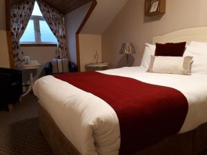 ein Schlafzimmer mit einem großen Bett mit einer roten Decke in der Unterkunft Jim McGee's in Wexford