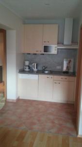 a kitchen with white cabinets and a microwave at Ferienwohnung Kogler in Waidring