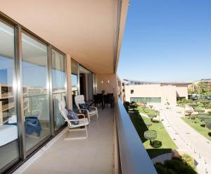 a balcony of a building with chairs and a table at Salgados, Relax & Fun for family in Guia