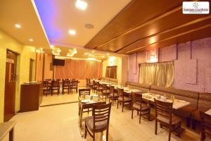 a restaurant with tables and chairs in a room at Hotel Sanman Gardenia in Bangalore