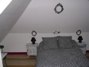 1 dormitorio con 1 cama y 2 relojes en la pared en CHEZ PIMLINE, en Saint-Aubin-sur-Quillebeuf