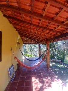 a porch with a hammock in a house at Hospedaria Pertim do Céu in São Francisco Xavier