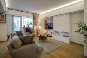 a living room with a couch and a tv at Visit Bucharest Romana Square Central Apt. - Metro in Bucharest