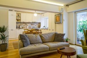 a living room with a couch and a kitchen at Visit Bucharest Romana Square Central Apt. - Metro in Bucharest