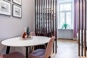 une salle à manger avec une table et des chaises blanches dans l'établissement ZEUS Design Apartments, à Vienne
