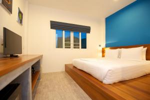 a bedroom with a bed and a flat screen tv at Thalassa - SHA Plus in Koh Tao