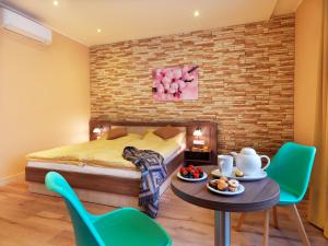 فندق فيكتور في براتيسلافا: غرفة نوم بسرير وطاولة وكراسي