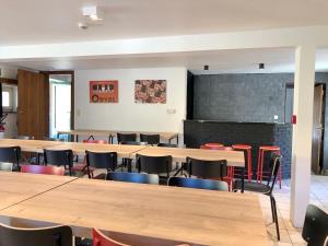 een grote kamer met tafels en stoelen en een schoolbord bij Moulin de Nawes in Herbeumont