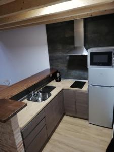a small kitchen with a sink and a microwave at Puente viejo de Buitrago casa Enebro in Buitrago del Lozoya