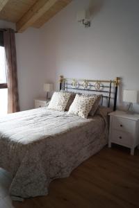 a bedroom with a large bed and two night stands at Puente viejo de Buitrago casa Enebro in Buitrago del Lozoya