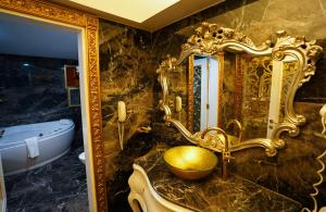 イスタンブールにあるHotel Buyuk Hamitのバスルーム(金の洗面台、鏡付)
