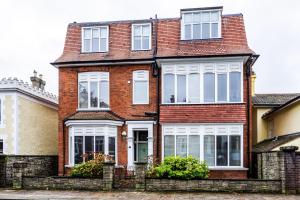 a red brick house with white windows at Spacious split level flat in great location in Portsmouth