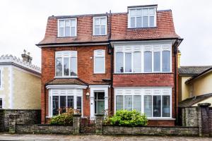 uma casa de tijolos vermelhos com janelas brancas em Spacious split level flat in great location em Portsmouth