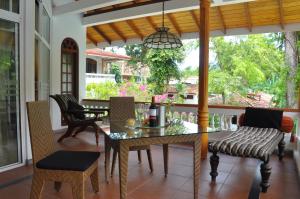 Ayubowan Swiss Lanka Bungalow Resort في بينتوتا: فناء على طاولة وكراسي على شرفة