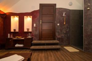 a room with a shower with a wooden door at Őshaza Vendégház in Bazsi +89 photos