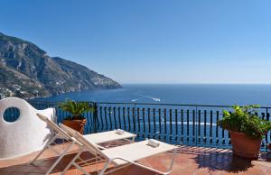 a balcony with two chairs and a view of the ocean at Positano Luxury Villas in Positano
