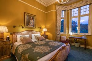 a bedroom with a bed and a desk and windows at Albero Bedrooms in Bedford