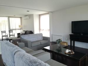 sala de estar con sofá y TV en suites del champaqui en Villa General Belgrano